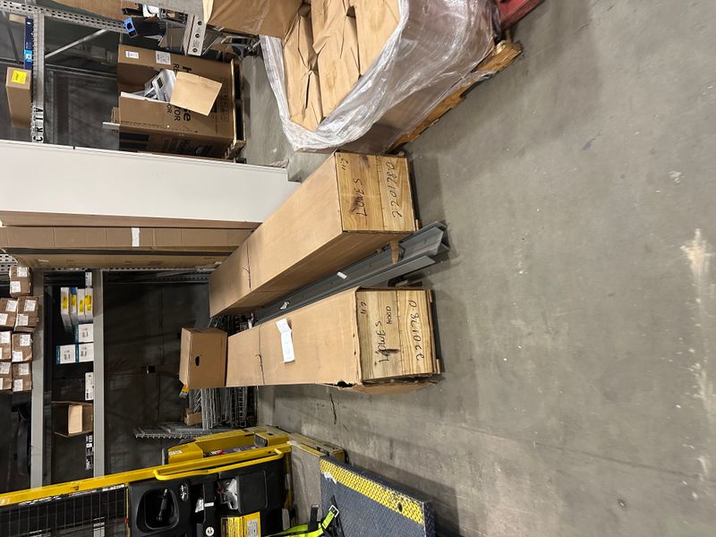 Garage door parts and materials on pallets in warehouse ready for installation — MA